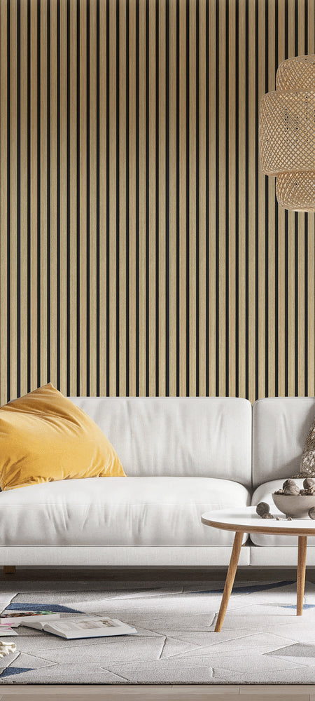 Woonkamer met akoestische lattenwand in wit eiken achter een witte bank en rotan hanglamp